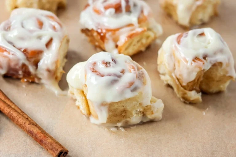 Frosted mini cinnamon rolls on brown paper.