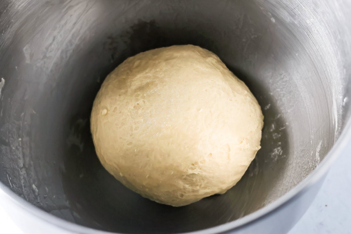 Mini cinnamon roll recipe dough in a metal bowl.