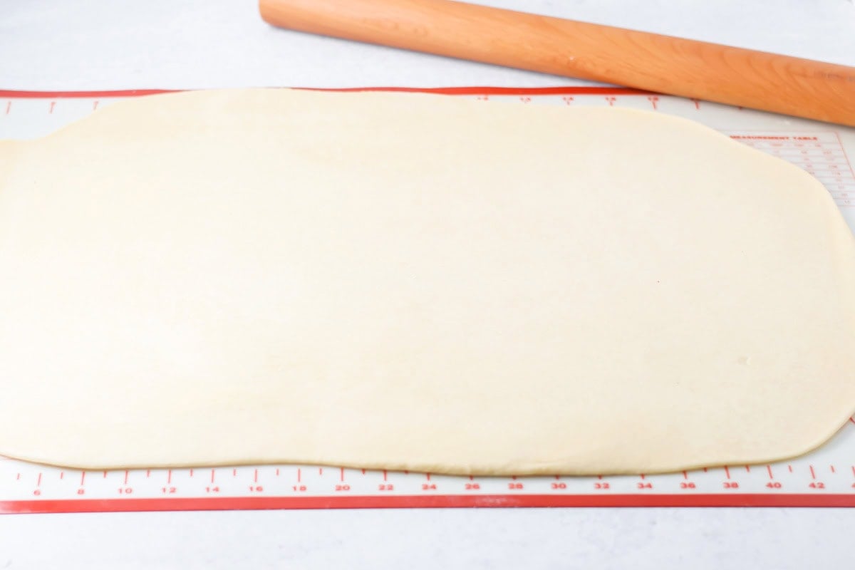 Rolled mini cinnamon roll dough on a silpat mat.