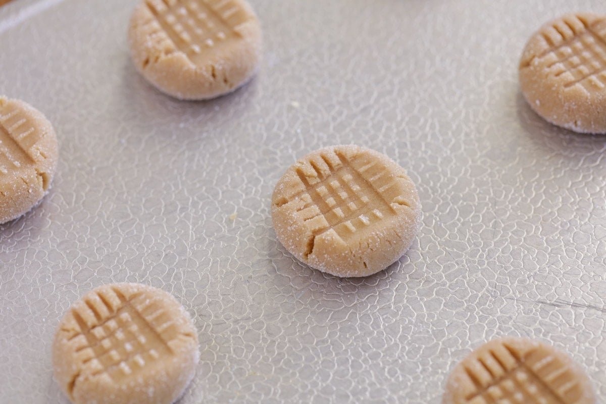 Easy peanut butter cookies lined upon a cookie sheet