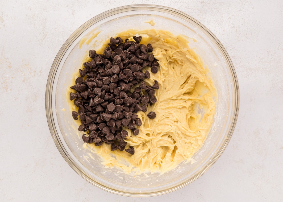 Adding chocolate chips to cookie batter.