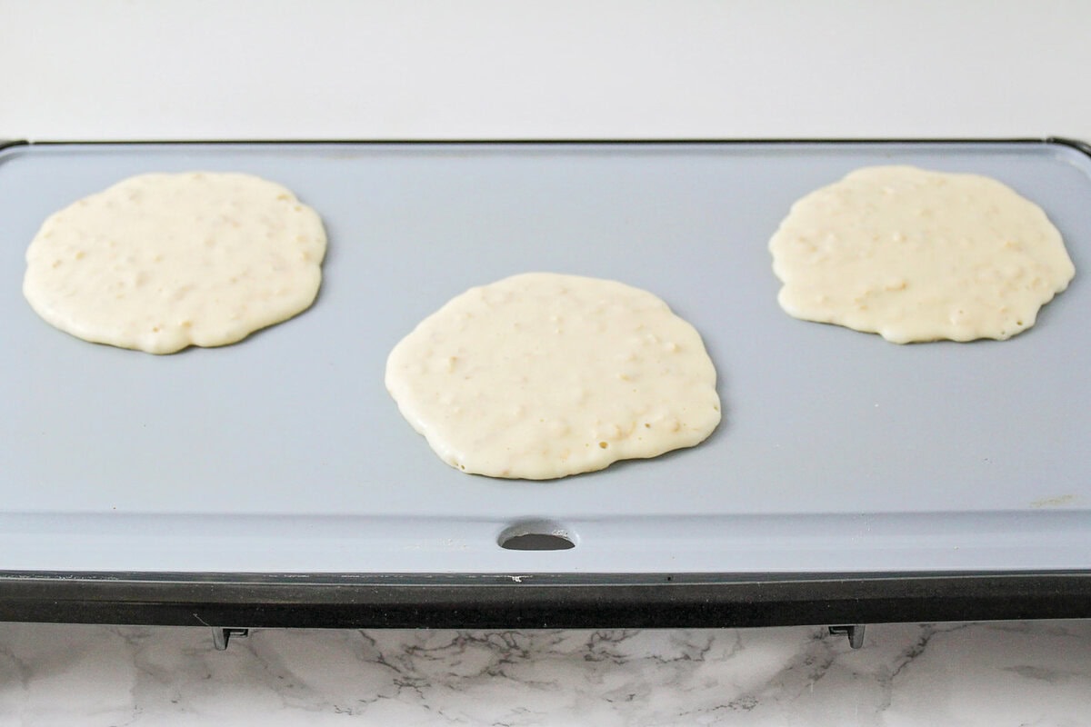 Cooking oatmeal pancakes on a griddle.