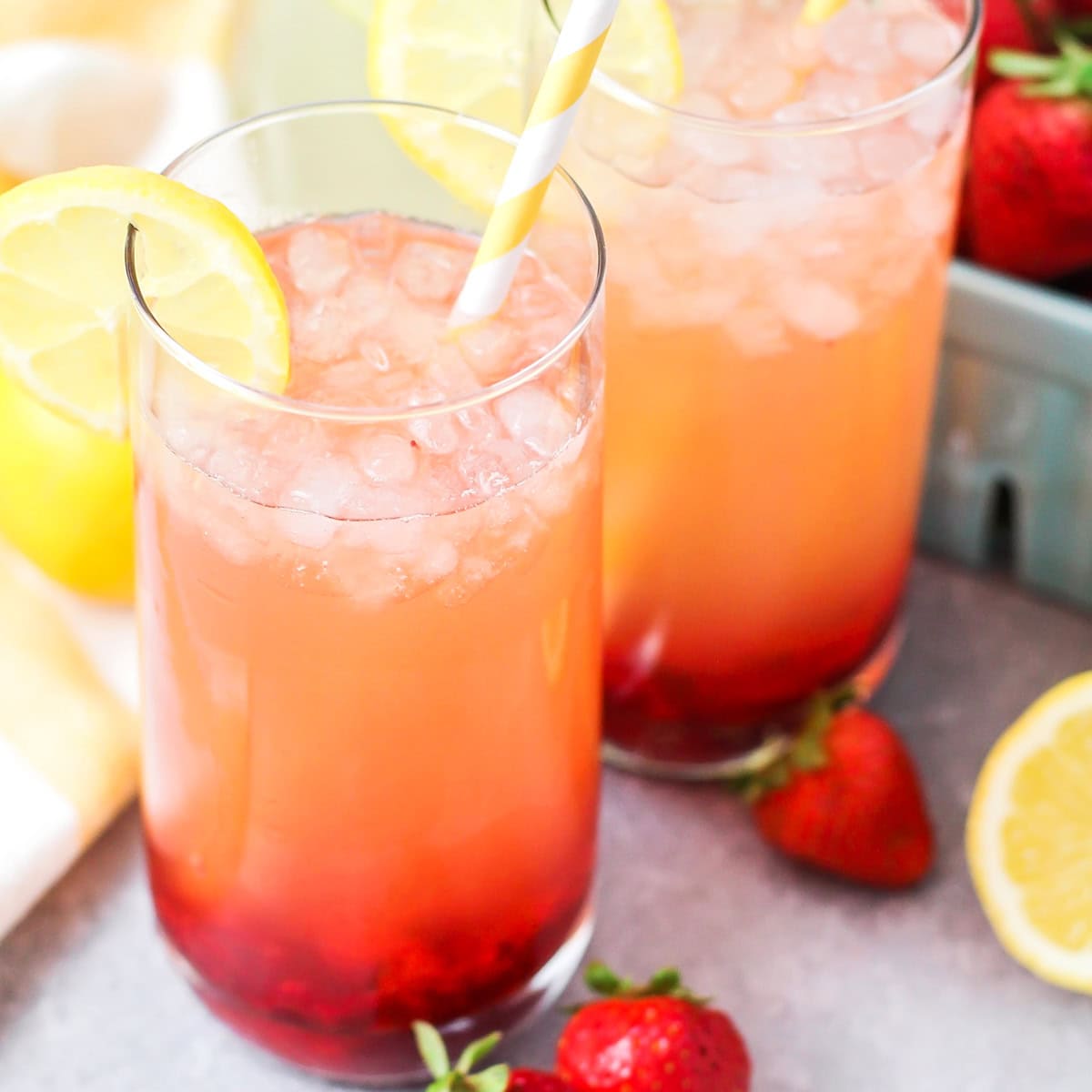 Two glasses of best strawberry lemonade with slices of fresh lemonns.