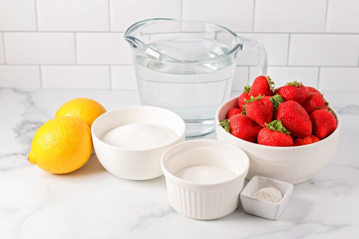 Best strawberry lemonade ingredients on a kitchen counter.