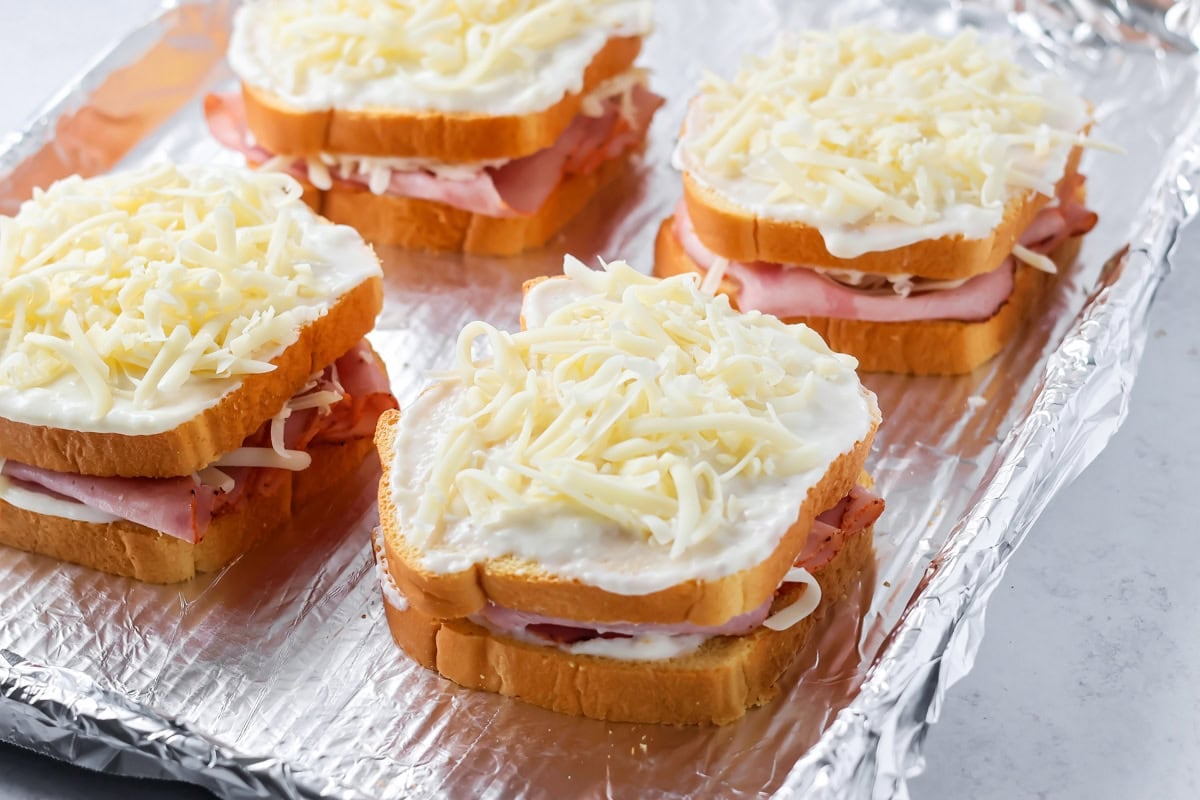 Croque Monsieur sandwich recipe on foil lined baking sheet.