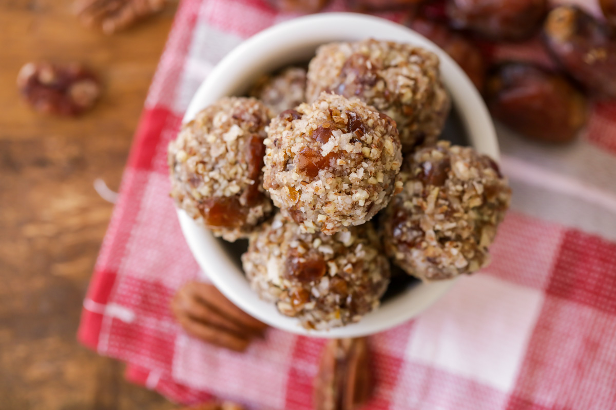 Date balls stacked on each other in small white bowl.