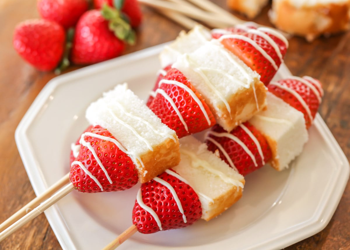 Valentine's Day Desserts - strawberry shortcake kabobs on wooden skewers on a white plate. 