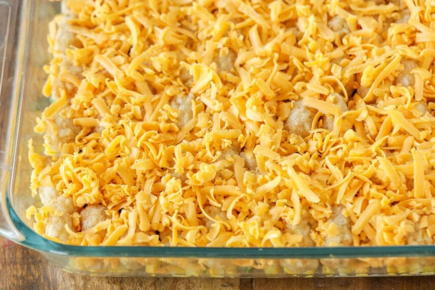 Homey & delicious hamburger tater tot casserole is layered with flavors everyone will love! It is kid-friendly, easy, and freezes perfectly! Hamburger and tater tot casserole topped with cheese in a glass baking dish.