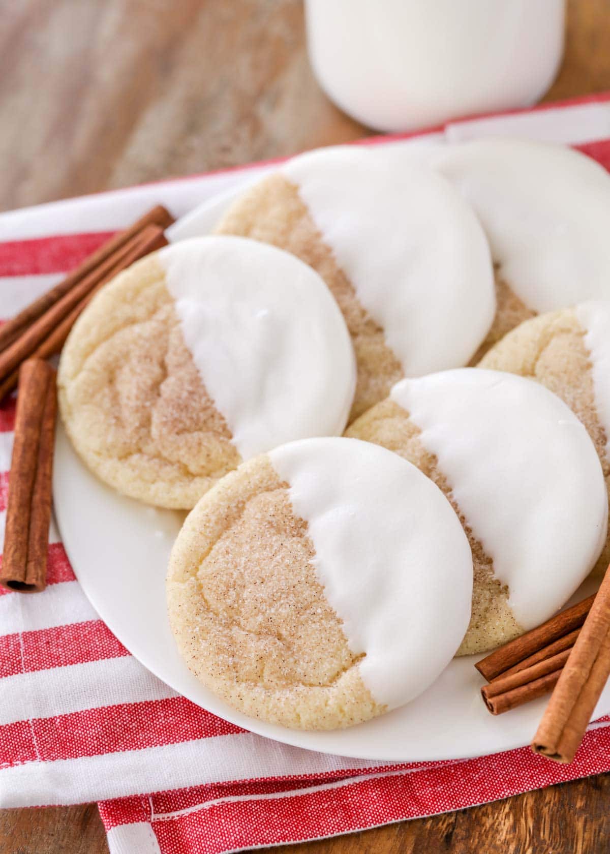 white chocolate dipped snickerdoodles stacked on a white plate