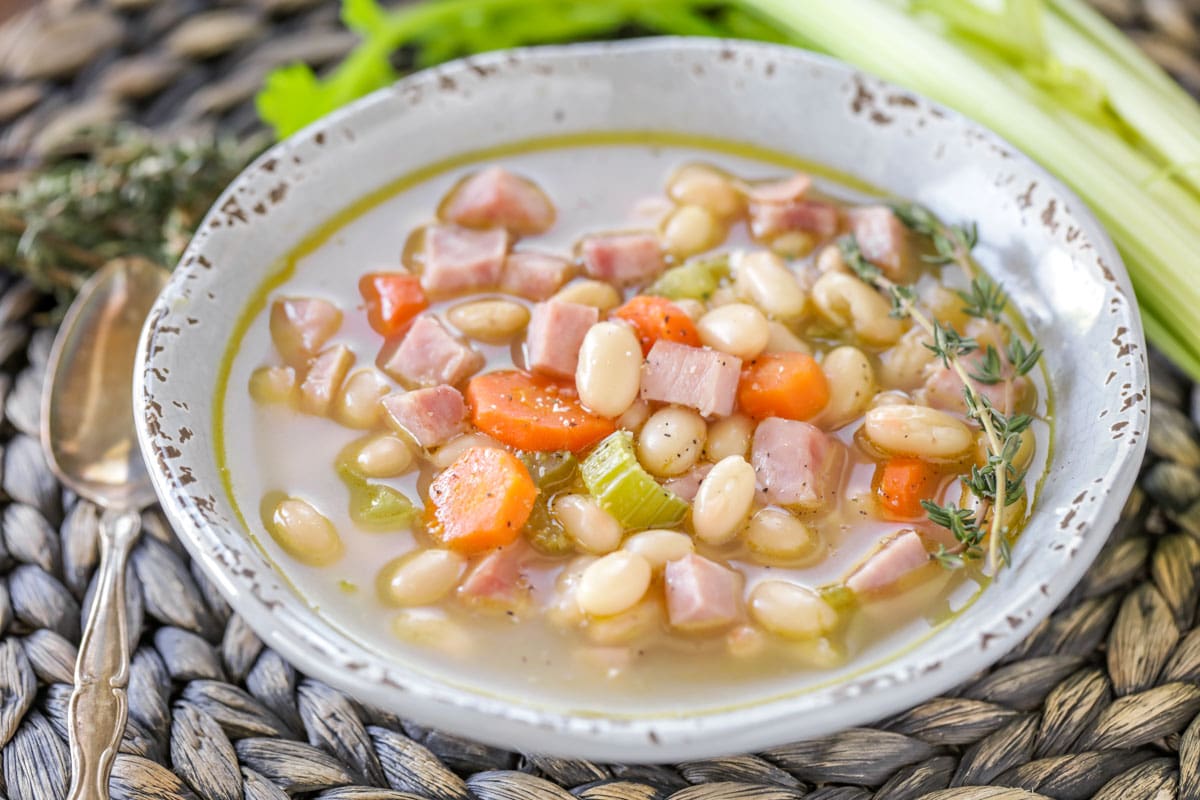 Ham and bean soup in a white bowl