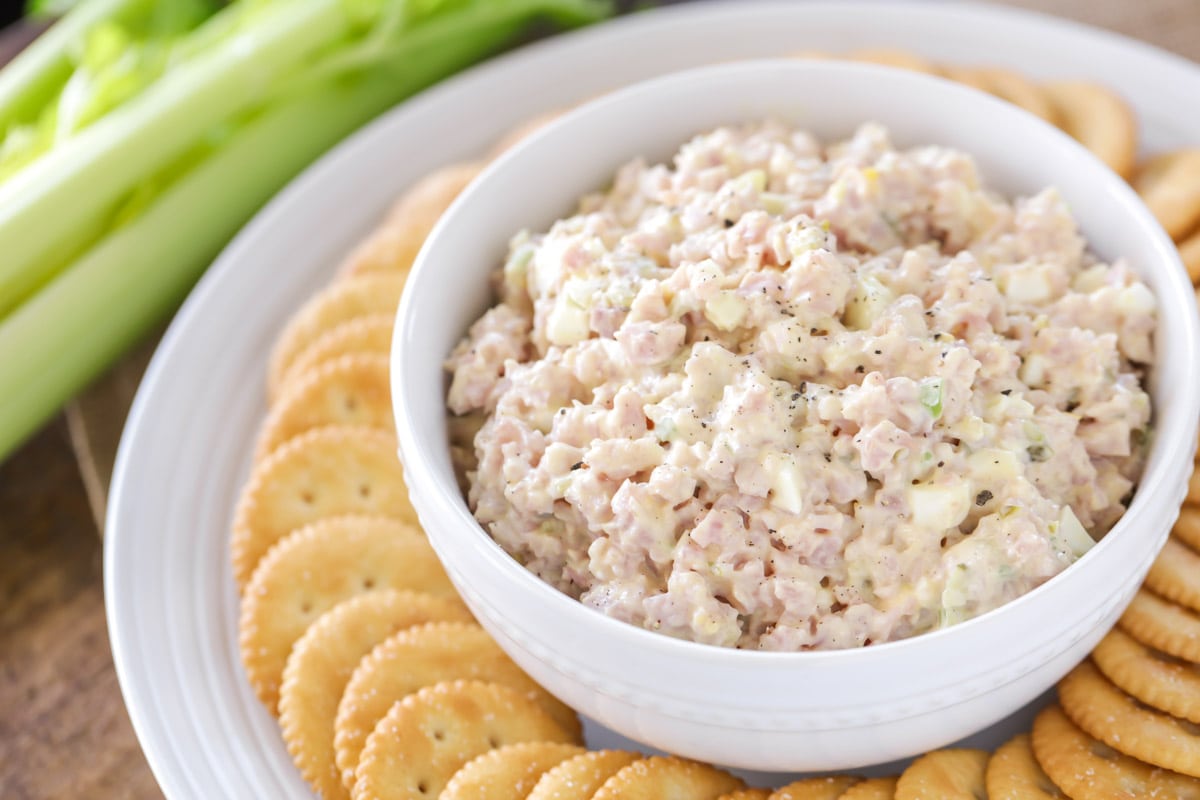 Ham salad recipe served in a white bowl with crackers