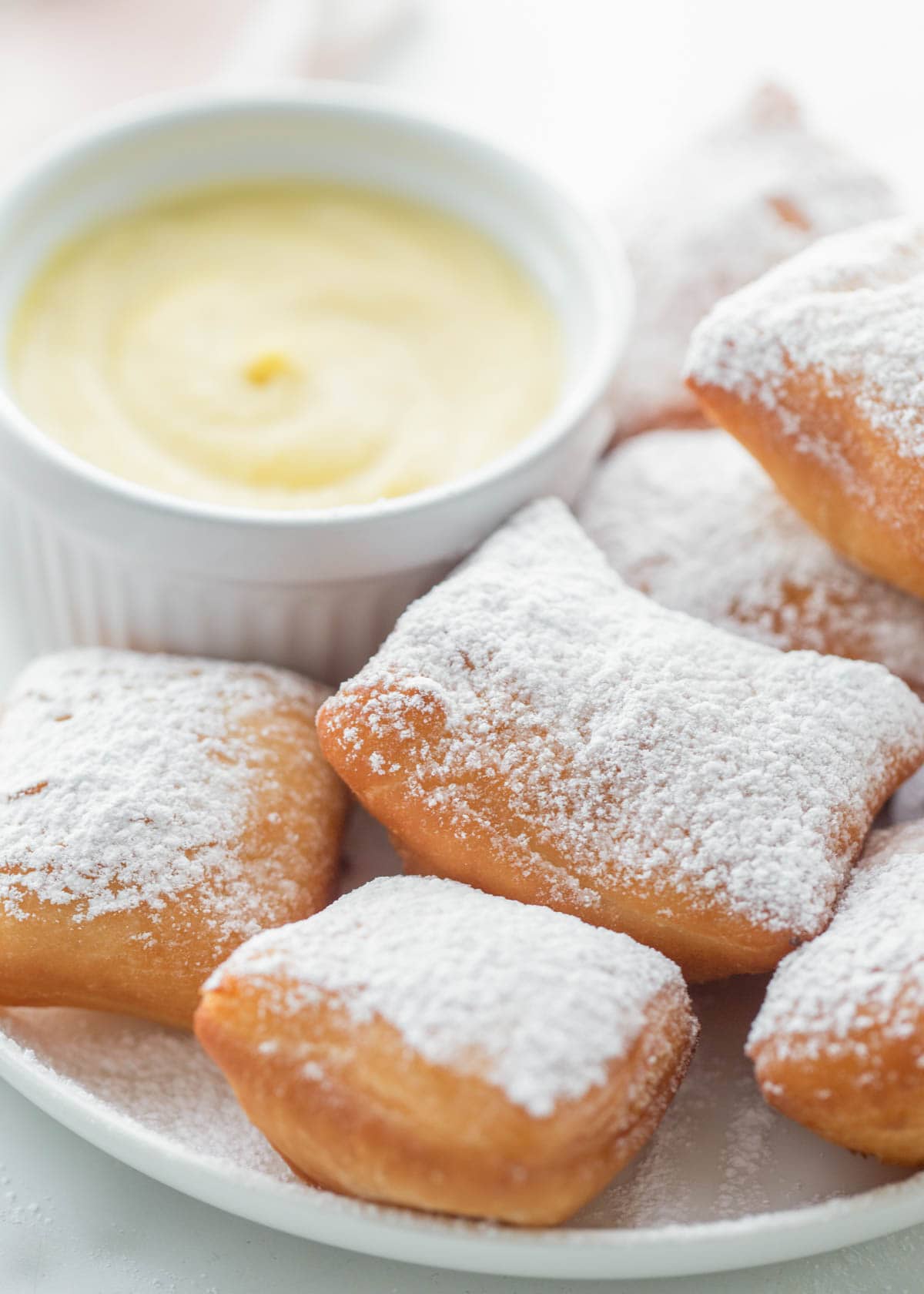 Custard dish filled with crème anglaise and served with powder sugar covered beignets