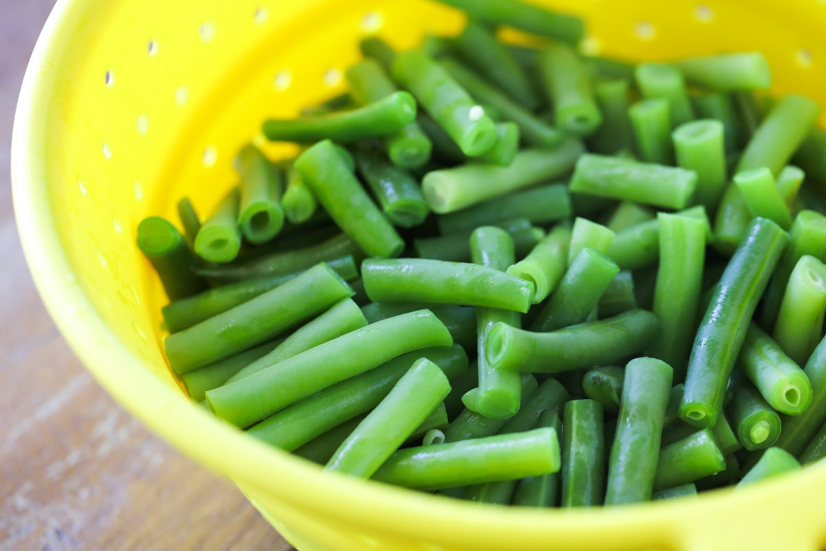 cooked fresh green beans in a yellow colander 