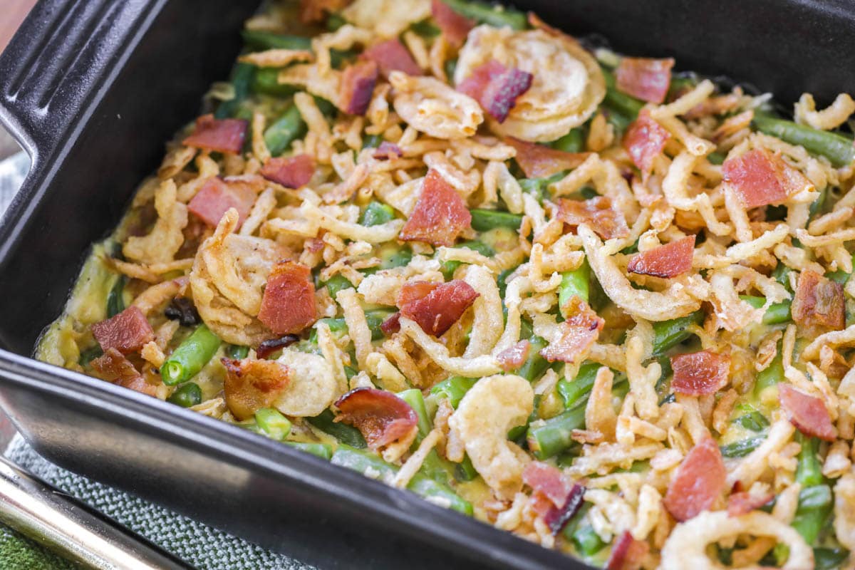 Thanksgiving side dishes - green bean casserole with bacon in a casserole dish.