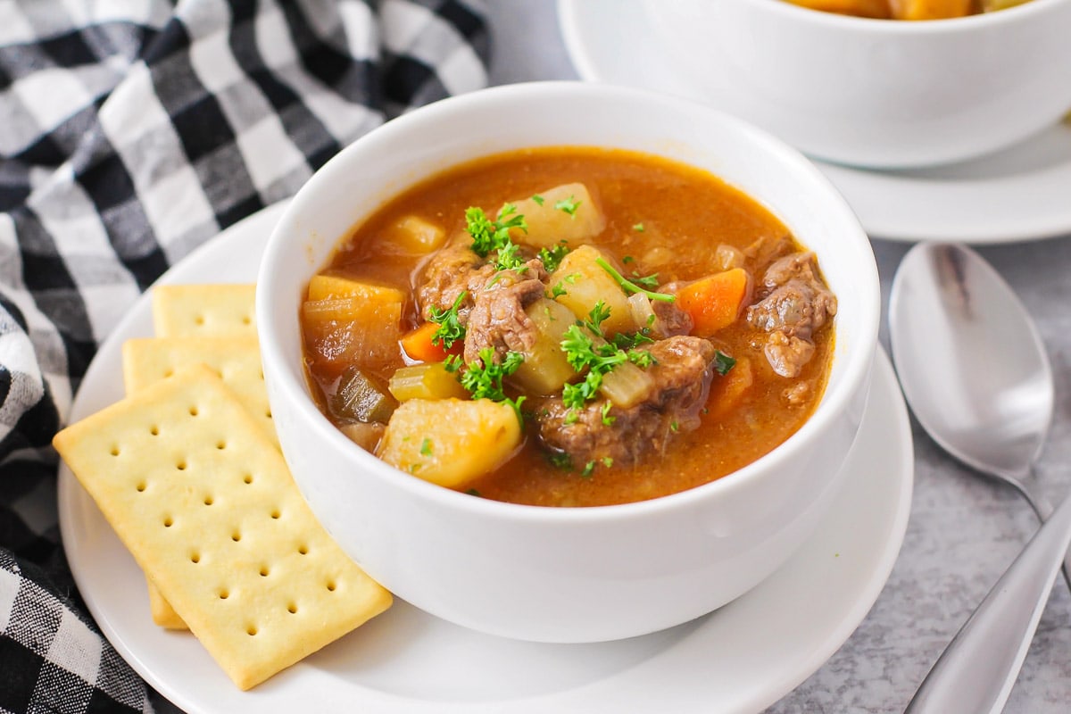 Instant Pot Beef Stew in a white bowl with club crackers on the side