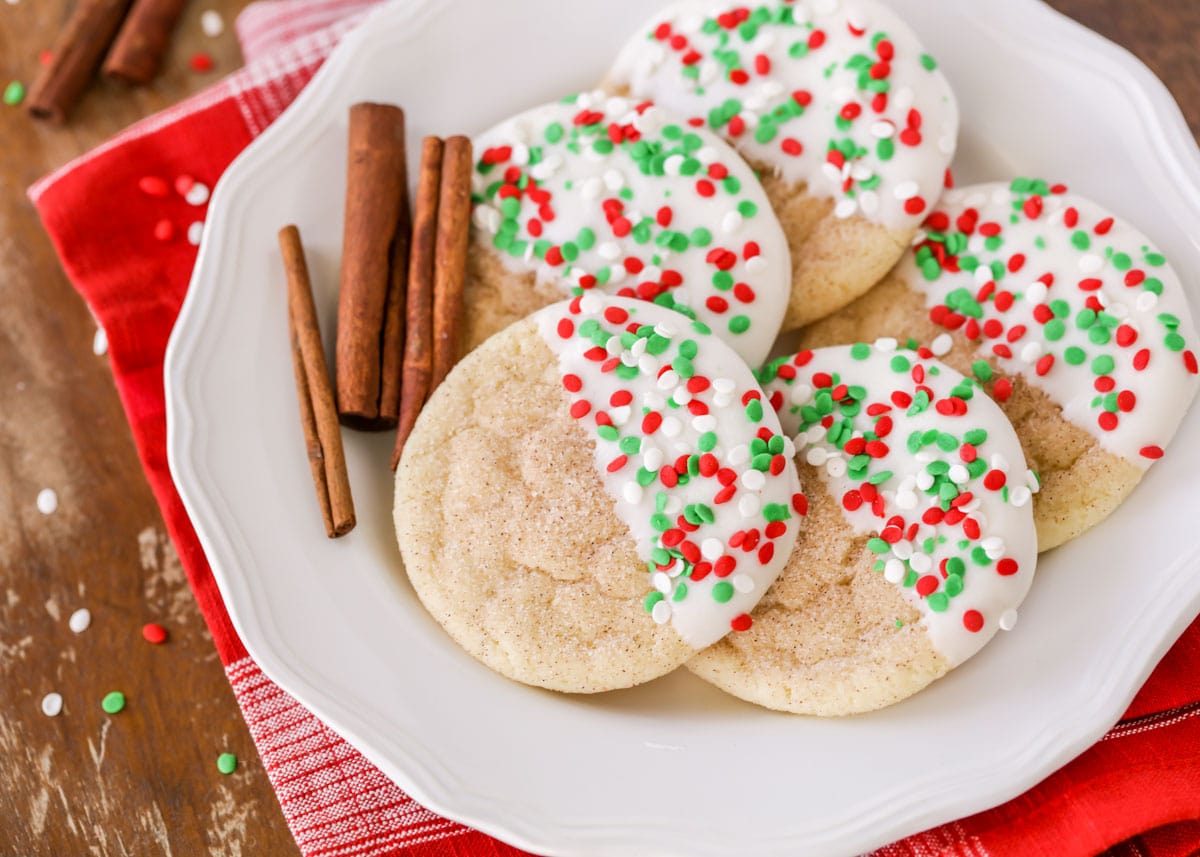 Christmas snickerdoodles dipped in white chocolate and sprinkled on a white plate
