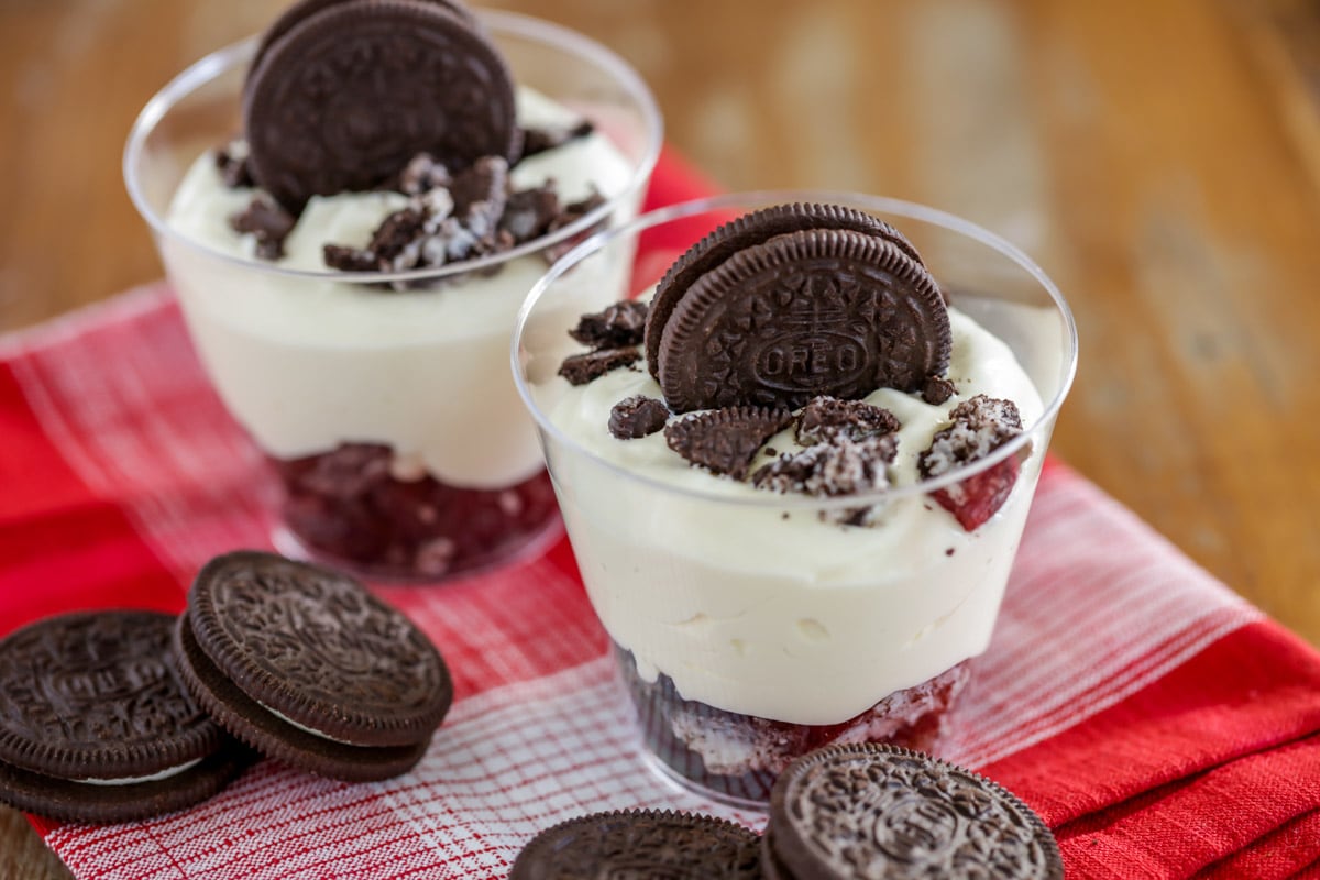 New years eve desserts - two dirt cake parfaits served in clear plastic cups, topped with oreo.