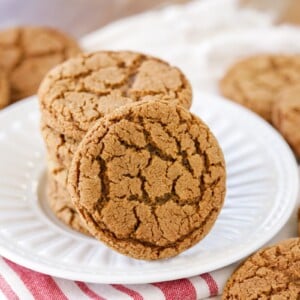 Molasses cookies stacked on a white plate.