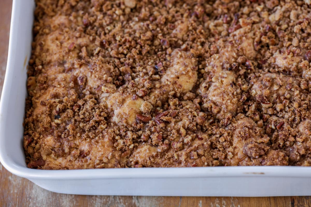 Close up of sour cream coffee cake in a white baking dish.