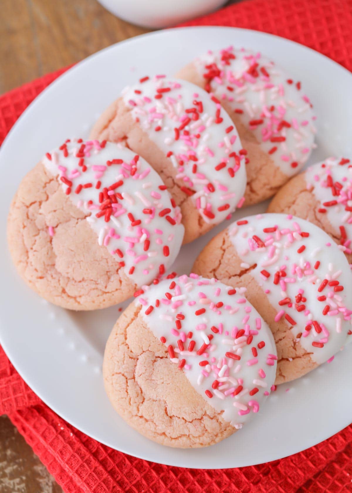 White chocolate dipped strawberry cookies on a white plate