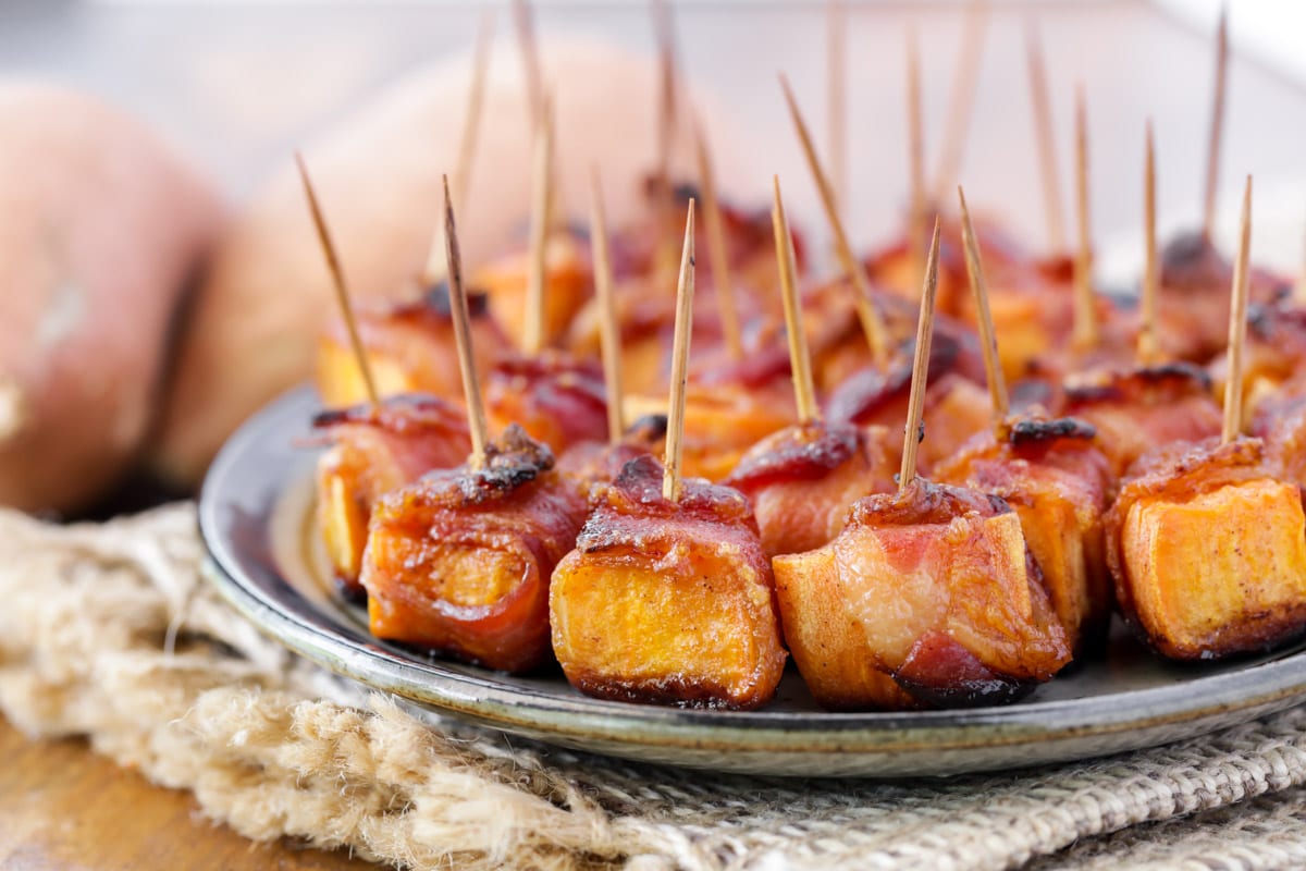Toothpicks stuck into bacon wrapped sweet potato bites.