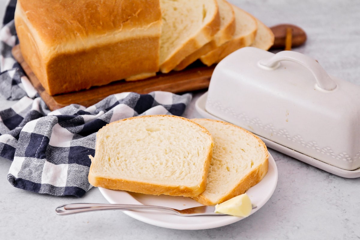 Yeast bread recipes - sliced sandwich bread served with butter.