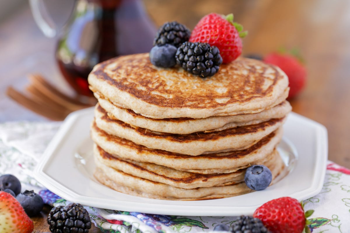 Easy pancake recipe - stacked on plate with fruit on top