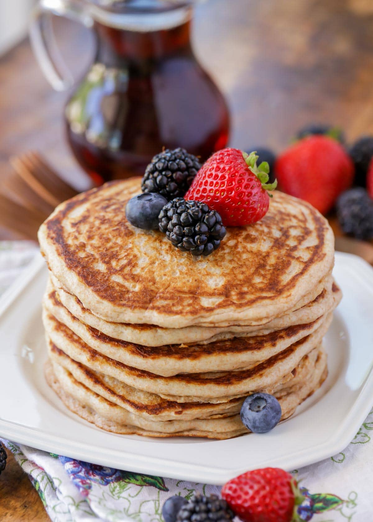 Stack of fluffy whole wheat pancakes topped with fresh berries