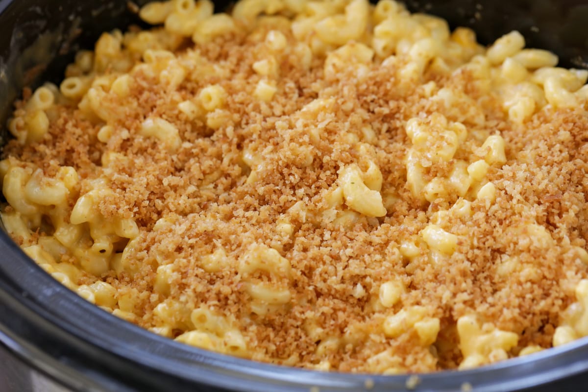 Cheesy macaroni in a crockpot topped with crumble.