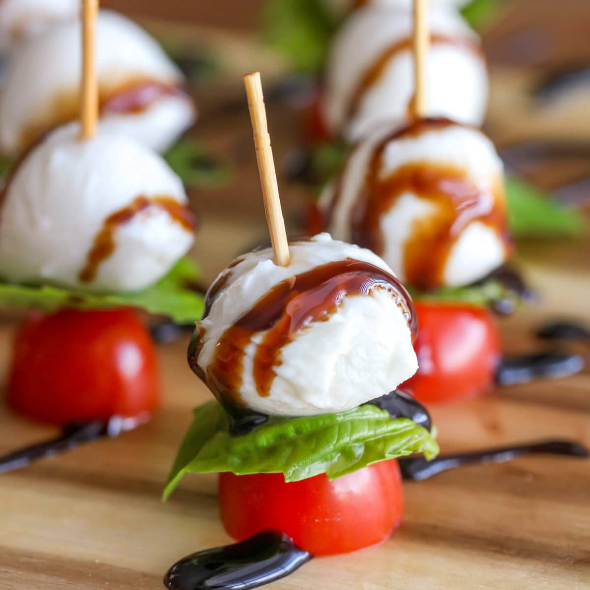 Super Bowl Appetizers - Caprese Kabobs with wooden toothpicks on a wood cutting board. 