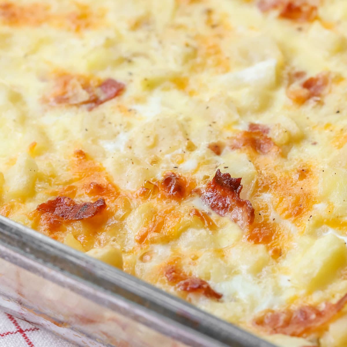 Thanksgiving breakfast ideas - a close up of cheesy breakfast casserole baked in a glass dish.