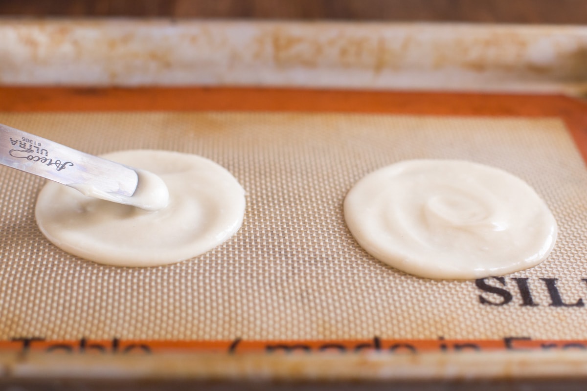 Spreading batter for two fortune cookies on a silpat mat