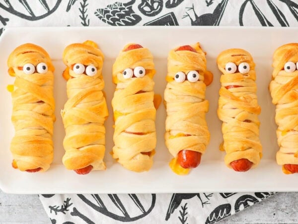 Mummy hot dogs served on white platter.