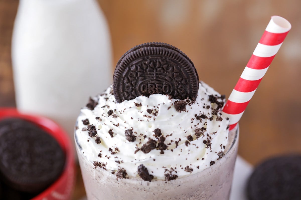 Oreo shake topped with an oreo and served with a paper straw.
