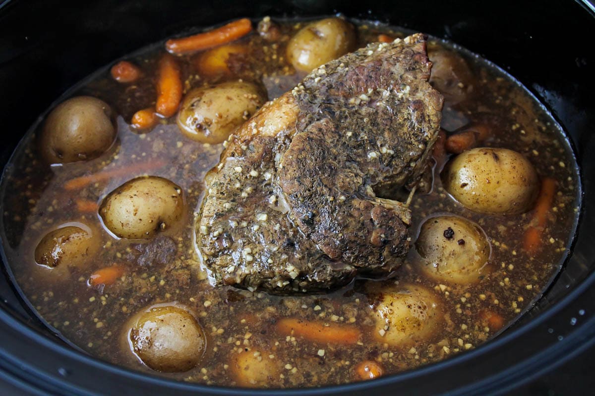 Cooking pot roast with veggies in a crock pot.