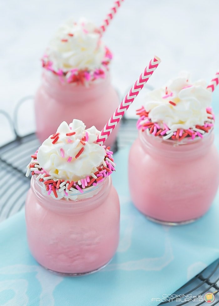 Three red velvet shakes in glass jars with straws