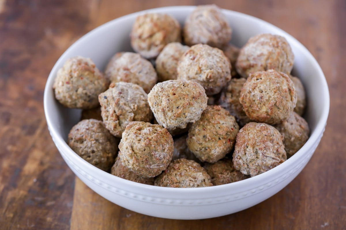 A bowl of frozen meatballs for sweet and sour meatballs.