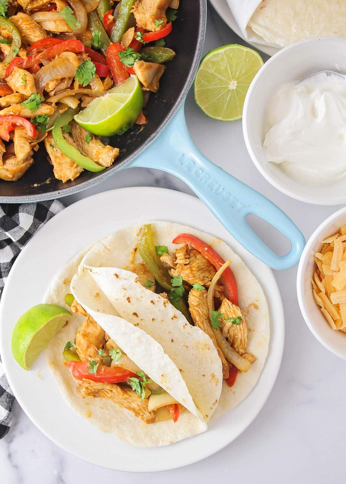 Chicken fajitas served up on a white plate.