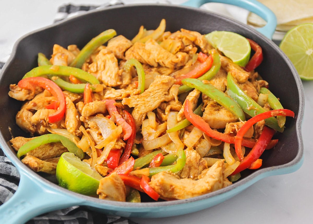 Pan filled with grilled Chicken Fajitas with onion and peppers.