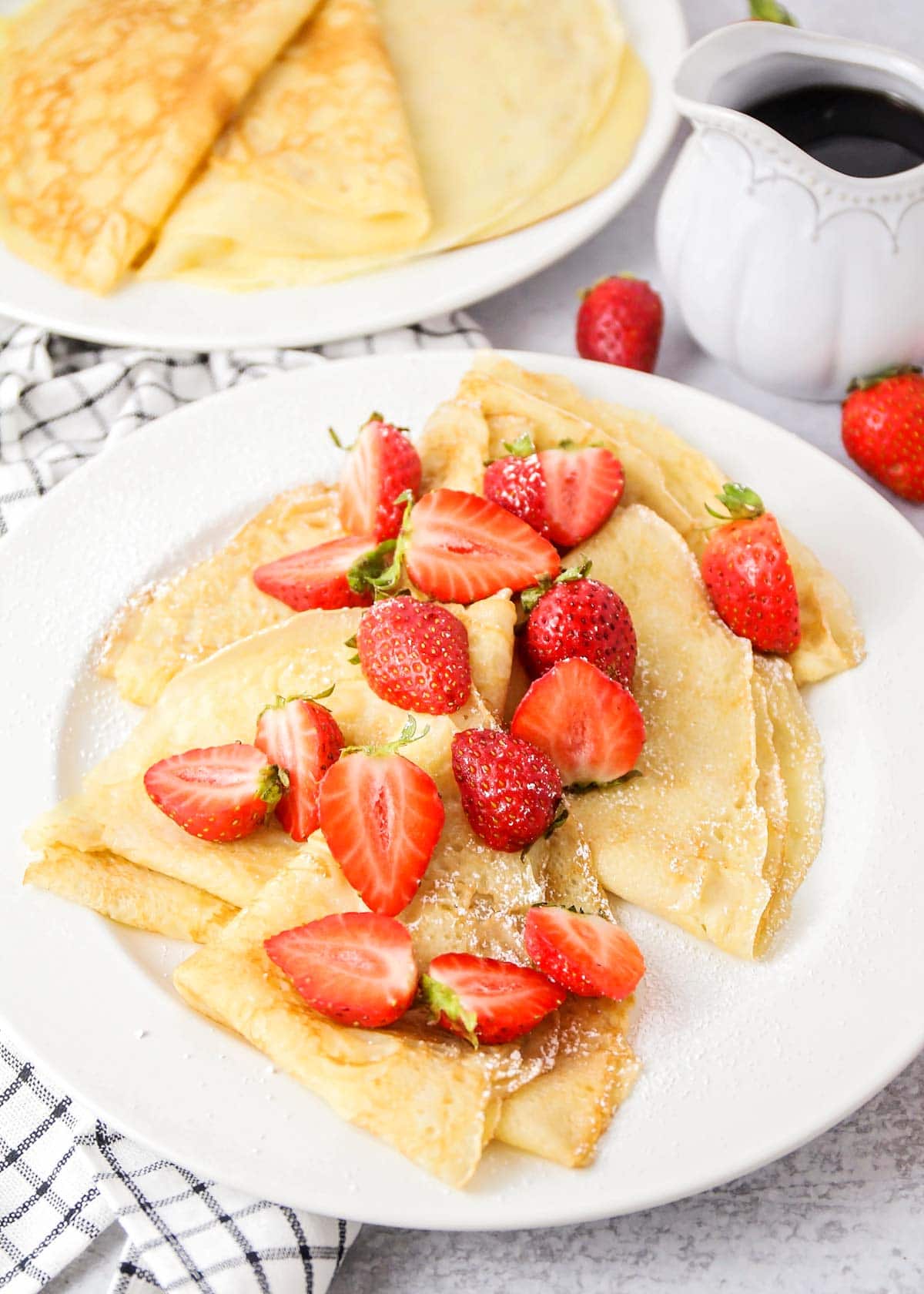 Easy crepe recipe topped fresh sliced strawberries.