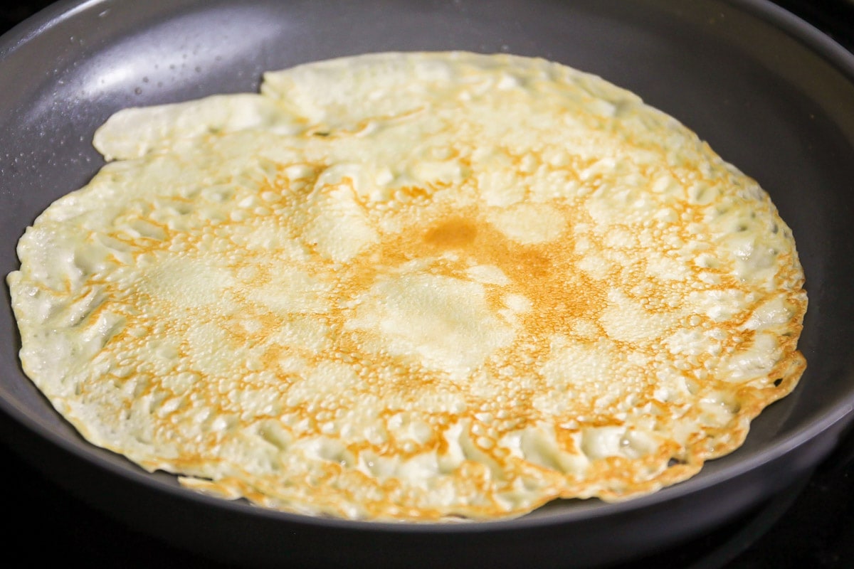 Cooking up fresh-baked crepes in a frying pan.