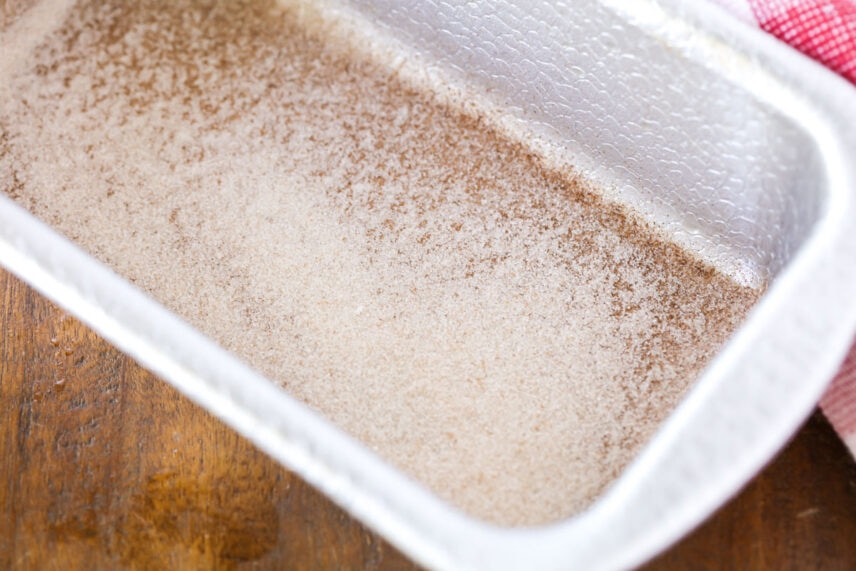 Cinnamon and sugar sprinkled into the bottom of a bread pan.