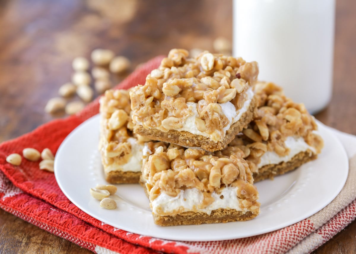 Cookie bar recipes - peanut topped oh henry bars piled on a white plate.