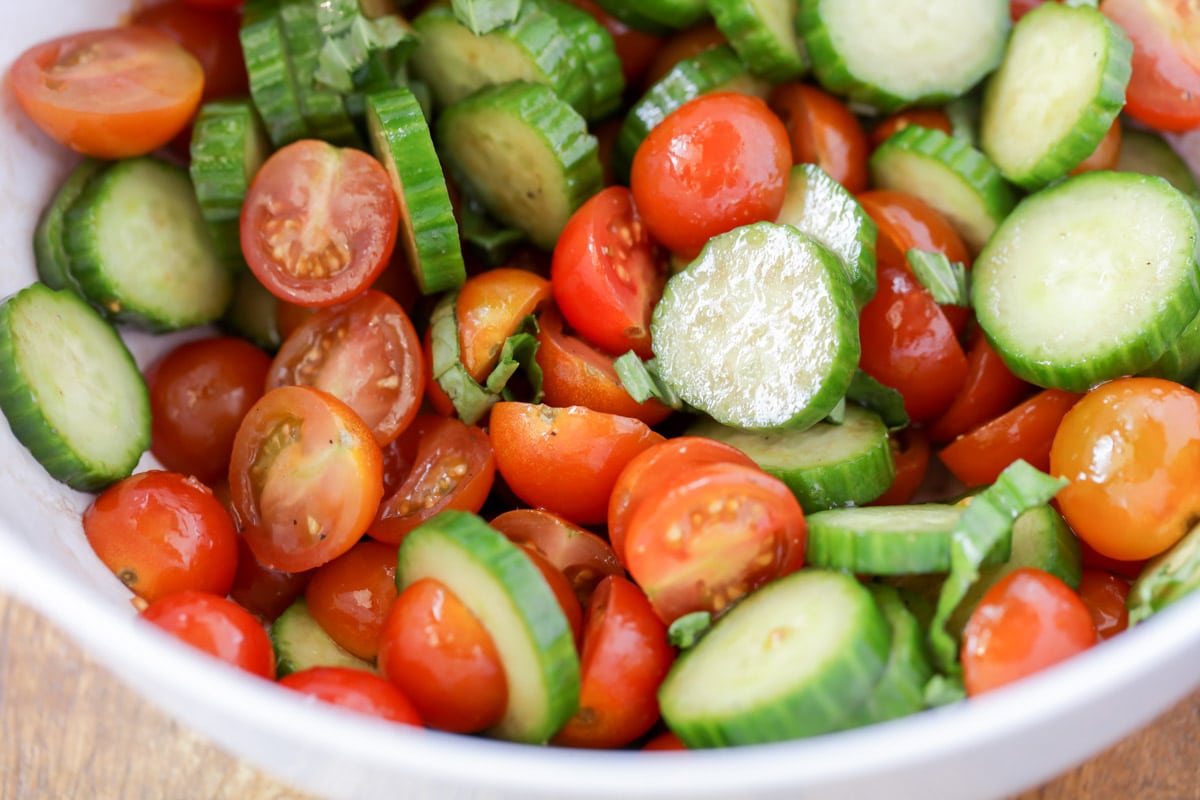 Fresh Cucumber Tomato Salad lightly dressed in a white bowl.