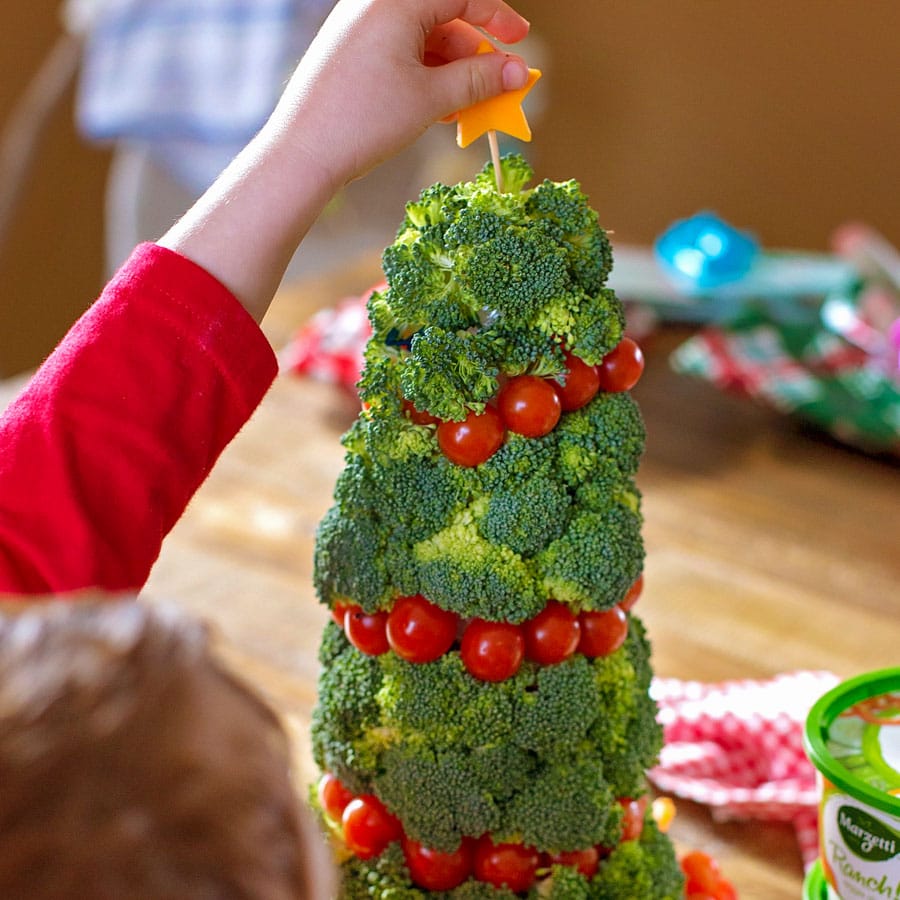 Christmas appetizers -  topping a veggie christmas tree with a cheese star.