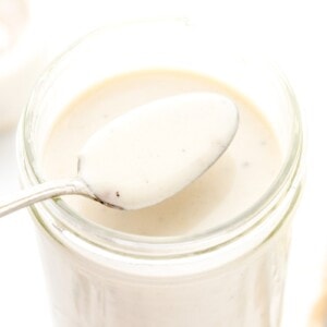 A spoon of easy Alfredo sauce from a jar.