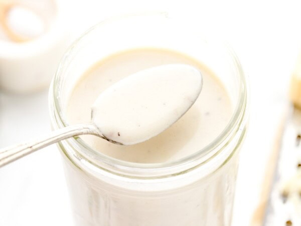 A spoon of easy Alfredo sauce from a jar.