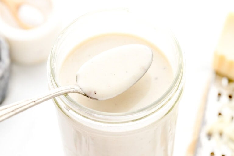 A spoon of easy Alfredo sauce from a jar.