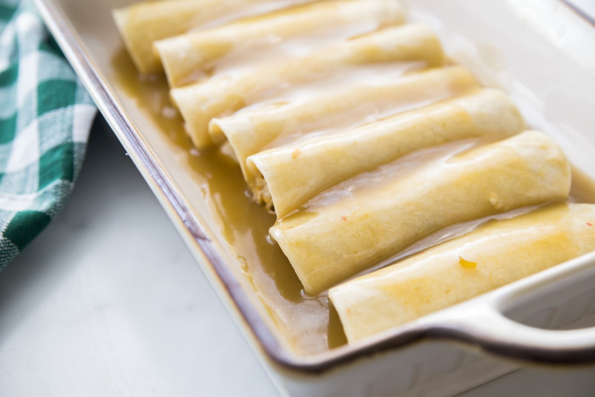 Seven chicken enchiladas in a baking dish