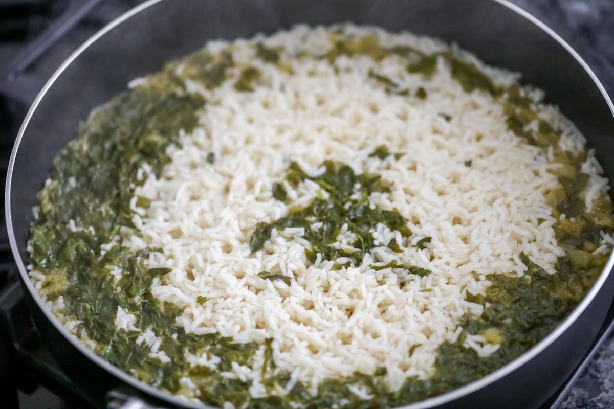 Cooked rice and cilantro in a pot.